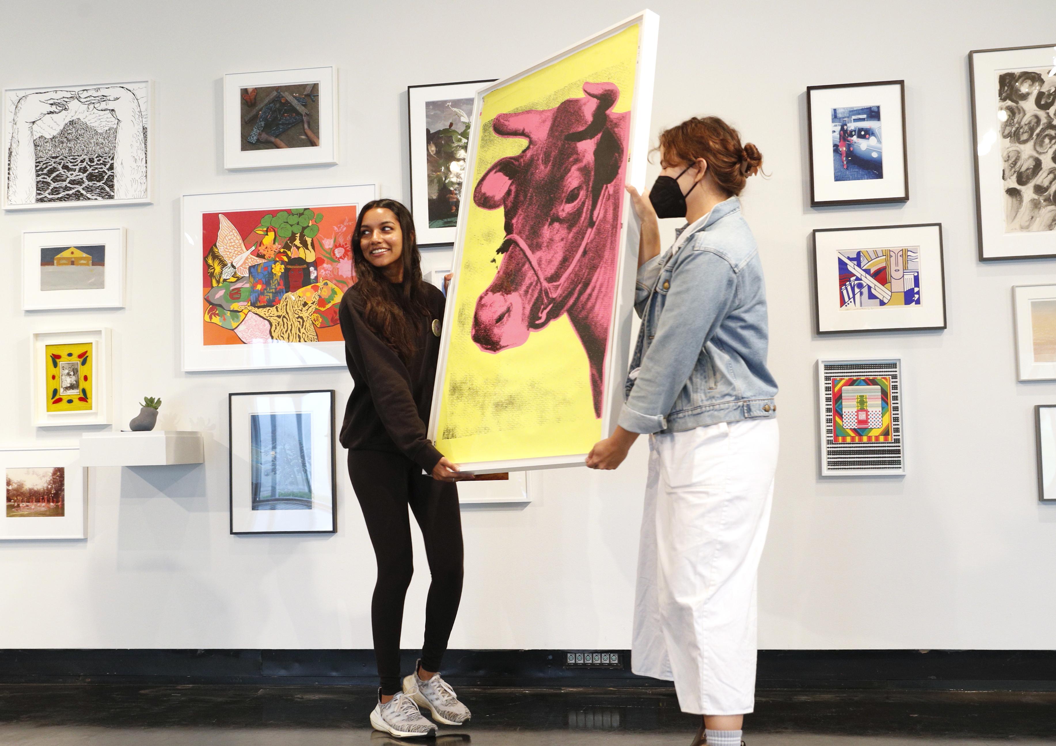 Qavalina Andrade ' 25, right, picks out an Andy Warhol print with Student Art Loan 项目协调员凯尔西·伦科说. 